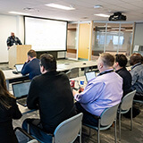 Les partenaires de Maple Disruption 2025 assistent à un exposé sur la collaboration intersectorielle.